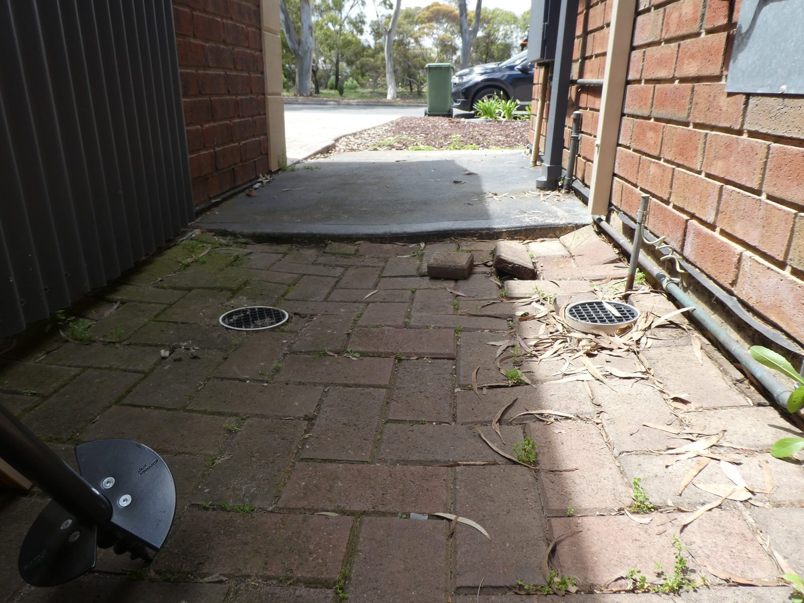 Sunken paving and surface drains beside a Golden Grove garage