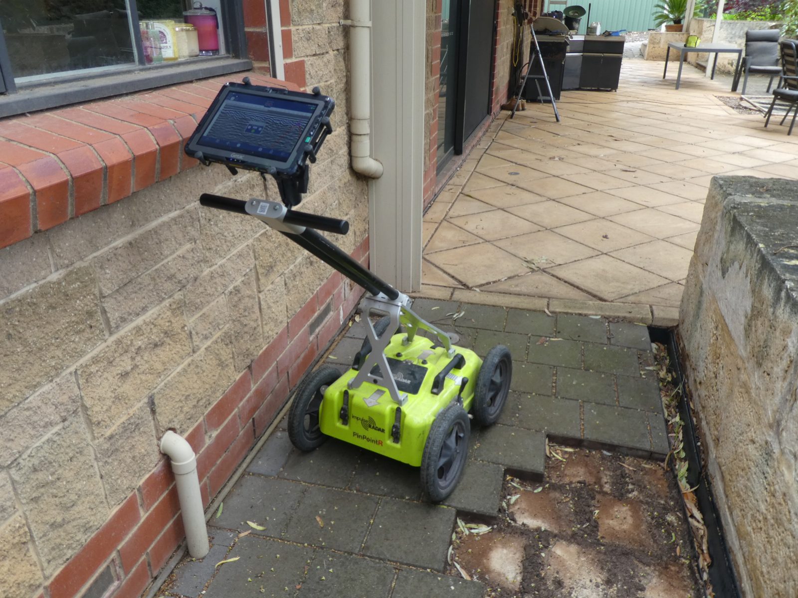 Ground penetrating radar cart scanning beside a Greenwith house