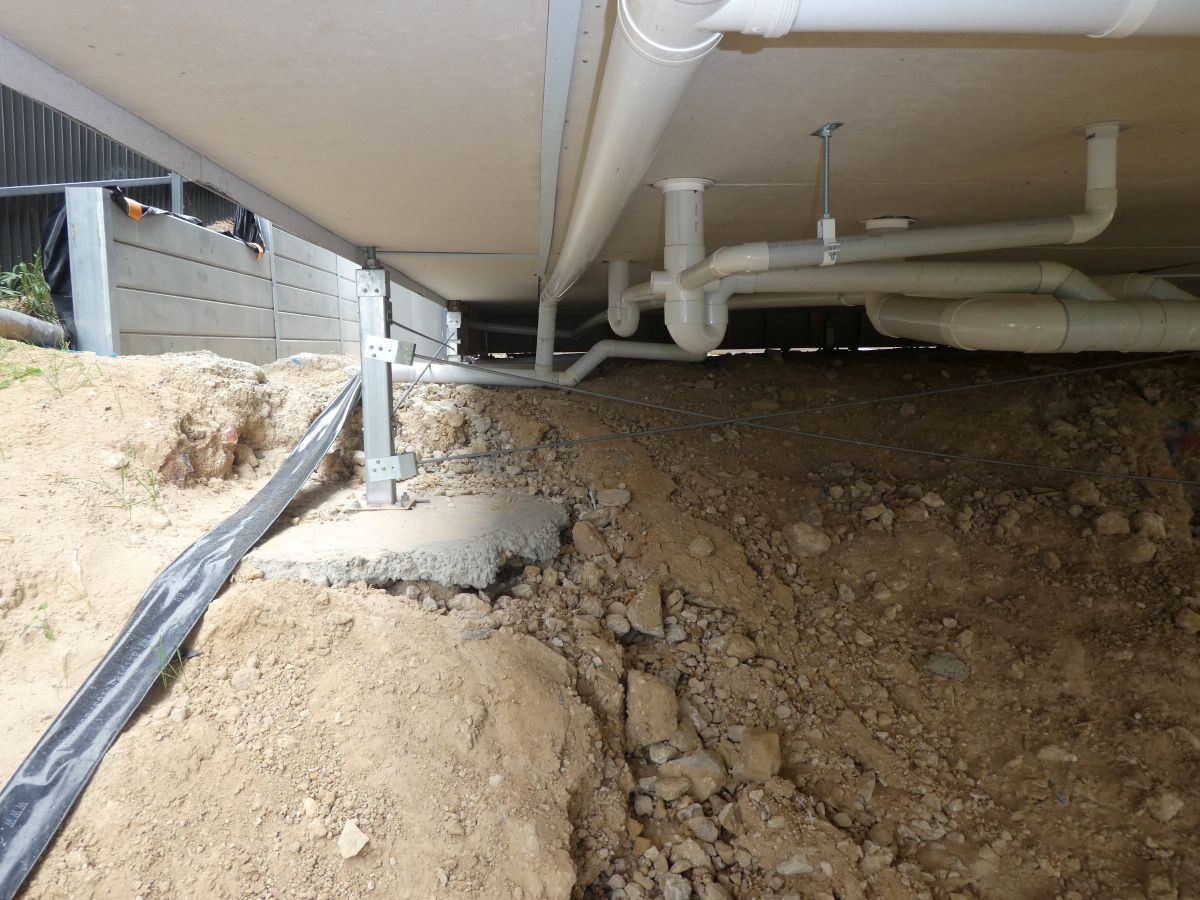 Eroded soil and exposed footing under a raised floor at Murray Bridge