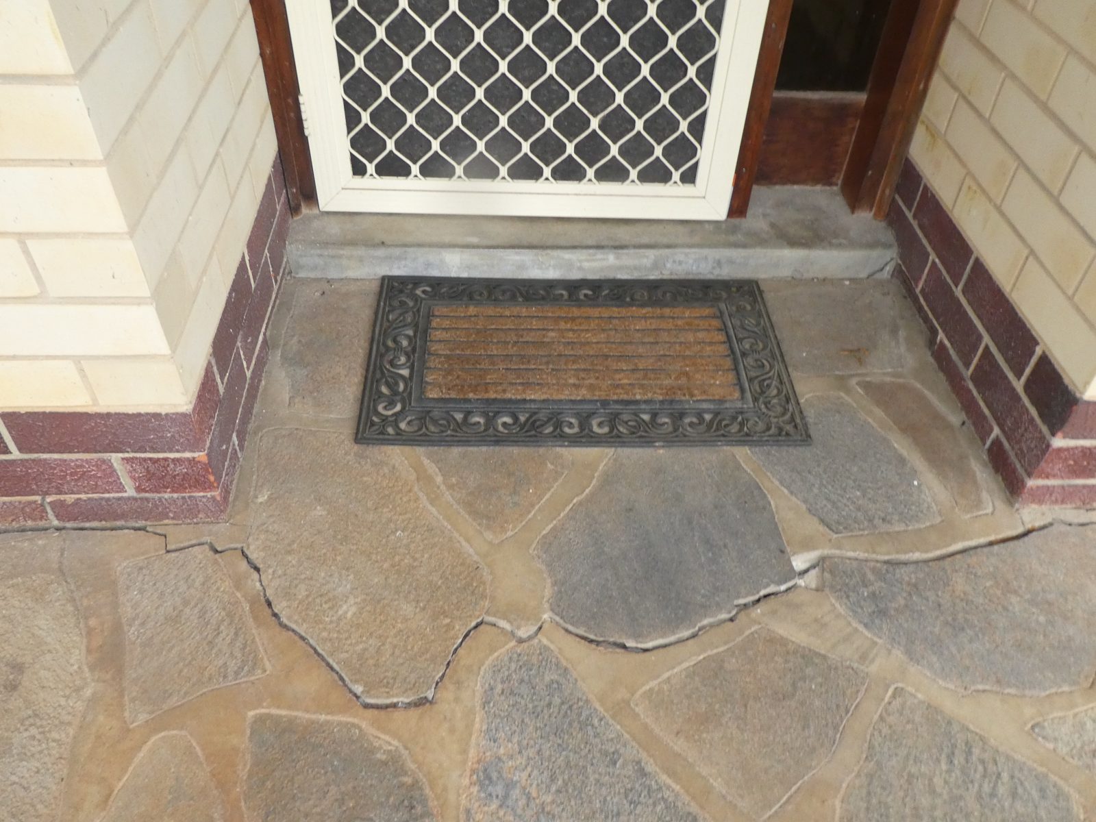 Cracked stone paving at the front entry of a Mylor house