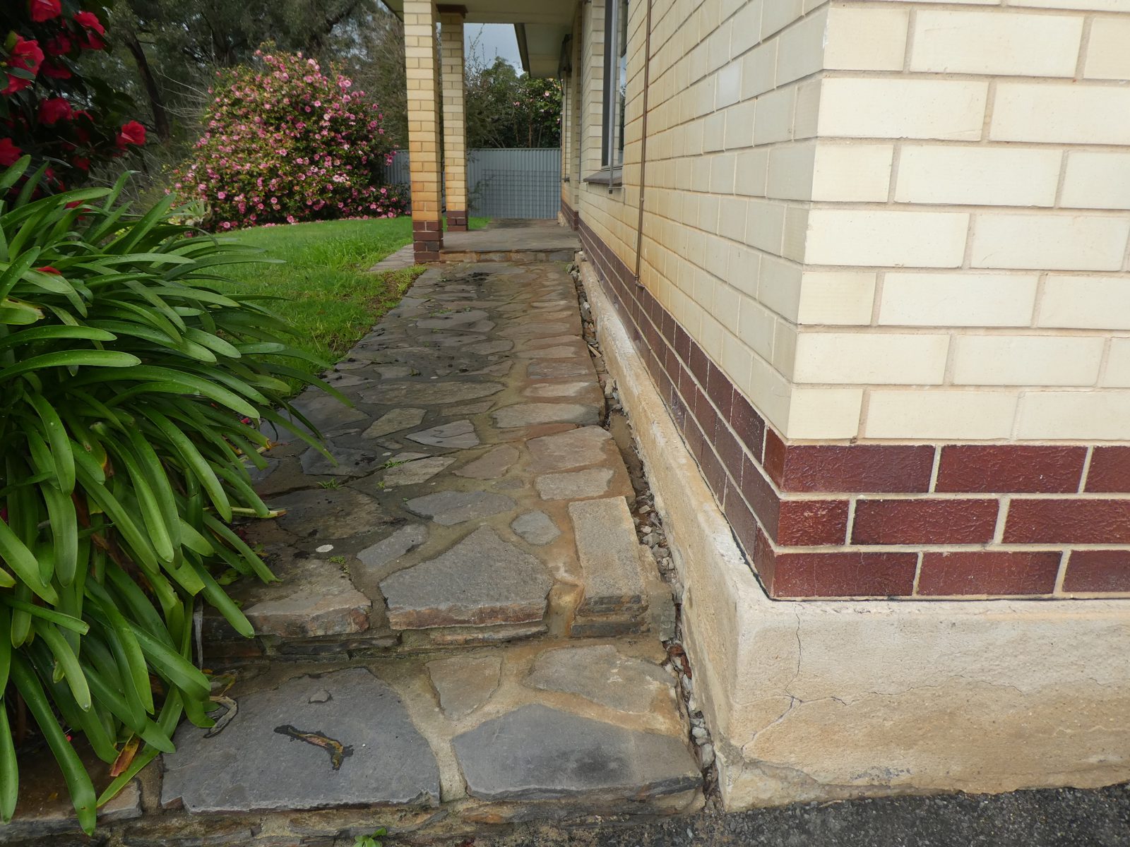 Stone path and brick footing edge during a pre-purchase inspection at Mylor