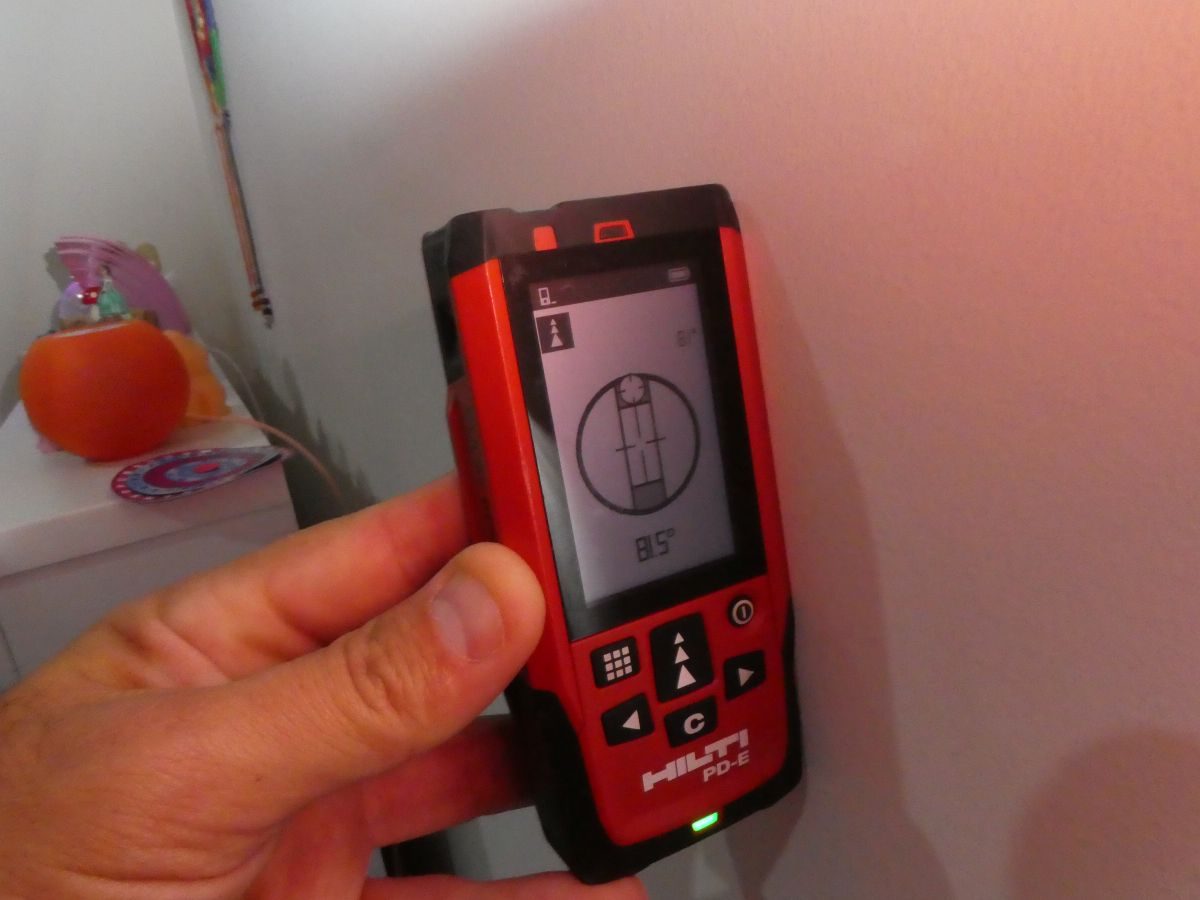 Laser distance meter checking wall plumb during a Tranmere inspection